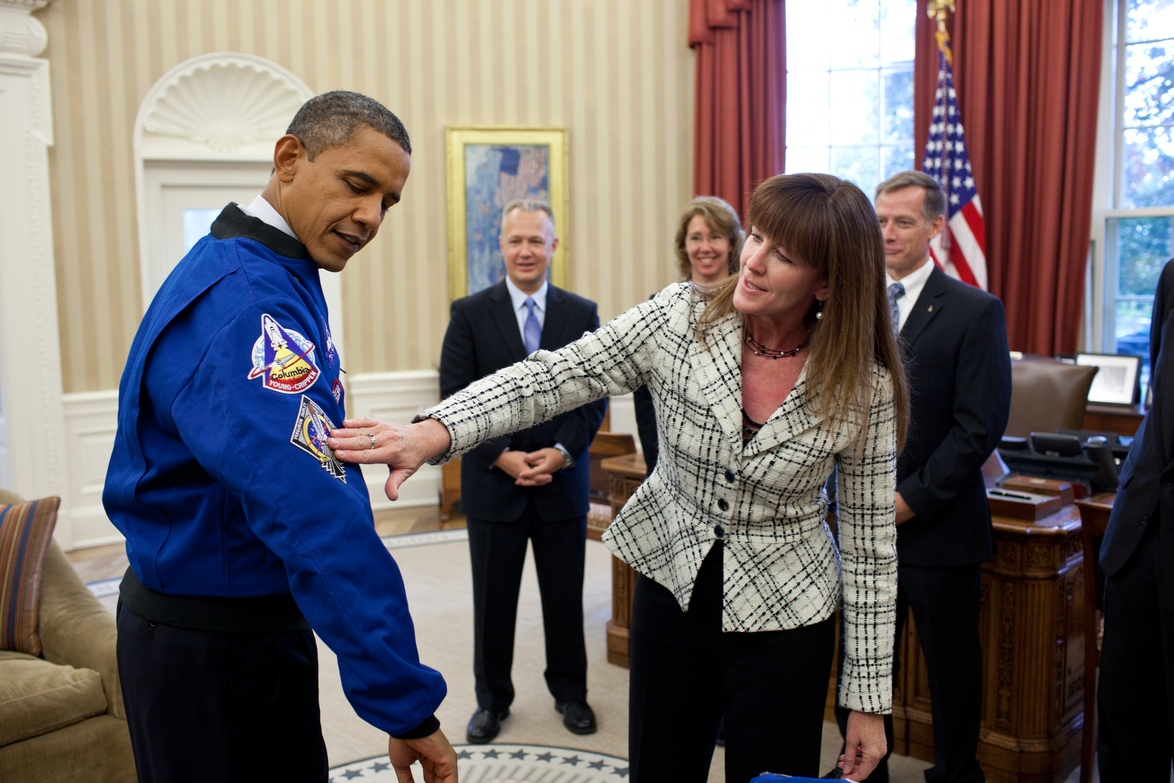 Janet Kavandi, Director of Flight Crew Operations at Johnson Space Center, presents President Obama with a jacket during a drop by with the crew of the Space Shuttle Atlantis in the Oval Office, Nov. 1, 2011. P110111PS-0434