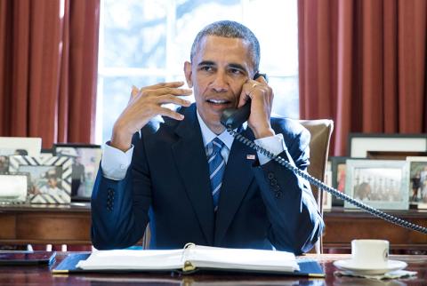 President Barack Obama talks on the phone with pastors who offer a birthday prayer during a call in the Oval Office, Aug. 4, 2015.