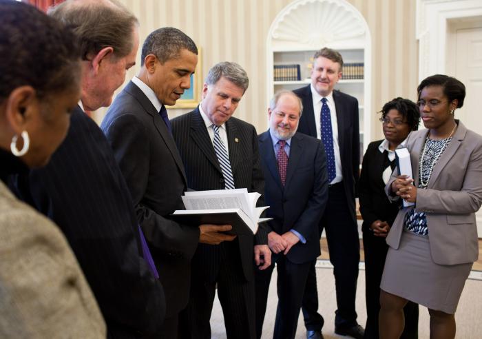 President Barack Obama receives a leather-bound 2009 edition of the "Public Papers of the Presidents of the United States" from David S. Ferriero, Archivist of the United States, center, in the Oval Office, Feb. 25, 2011. Joining them are staff from the Office of the Federal Register and National Archives and Records Administration.