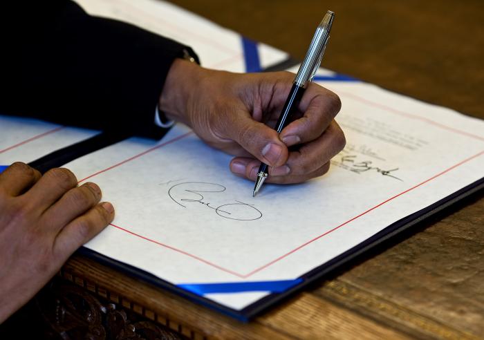 President Barack Obama signs a bill in the Oval Office, April 7, 2010.