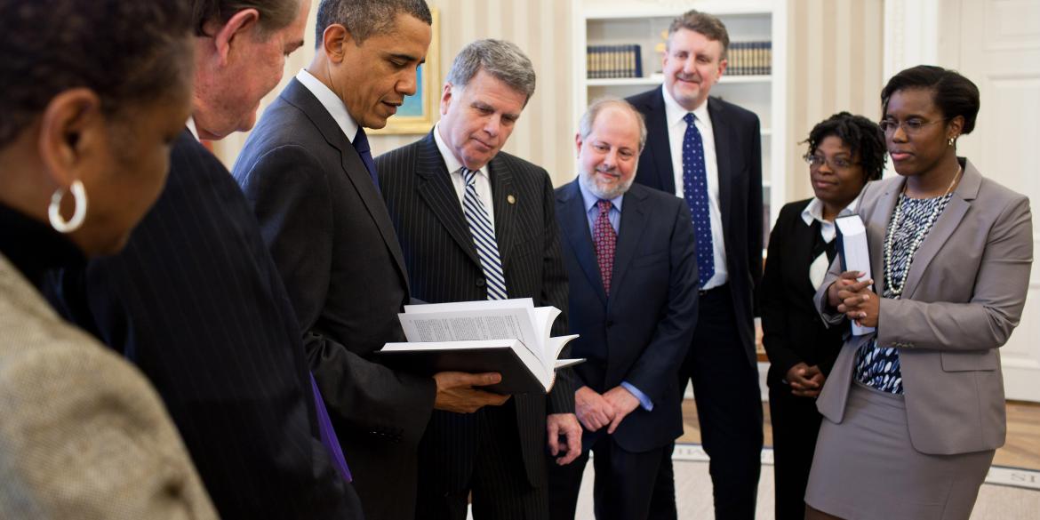 President Barack Obama receives a leather-bound 2009 edition of the "Public Papers of the Presidents of the United States" from David S. Ferriero, Archivist of the United States, center, in the Oval Office, Feb. 25, 2011. Joining them are staff from the Office of the Federal Register and National Archives and Records Administration.