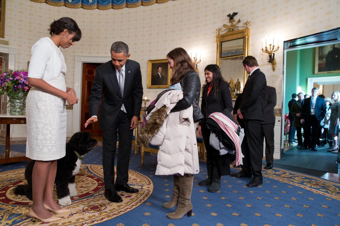President Barack Obama, First Lady Michelle Obama, and Bo, the Obama family dog, greet visitors during an inaugural open house in the Blue Room of the White House, January 22, 2013. 