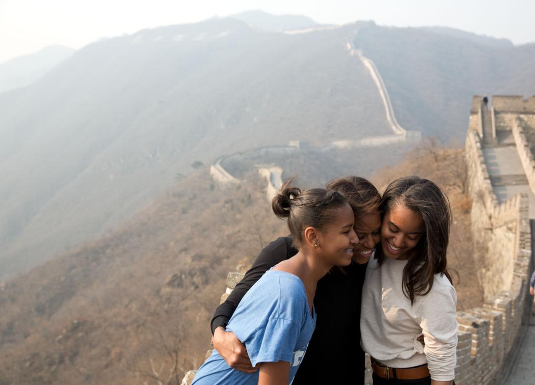First Lady Michelle Obama hugs daughters Sasha, left, and Malia as they visit the Great Wall of China in Mutianyu, China, March 23, 2014. 