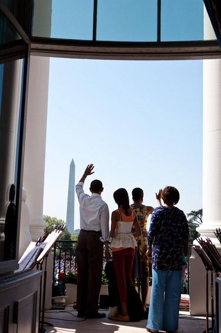 President Barack Obama and First Lady Michelle Obama wave to the crowd from the South Portico of the White House during the annual Easter Egg Roll, April 25, 2011. Daughters Malia and Sasha, Marian Robinson, and Bo, the Obama family dog, joined the Presid