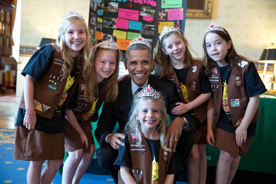 President Barack Obama wears a crown as he poses with Avery Dodson, Natalie Hurley, Miriam Schaffer, Claire Winton, and Lucy Claire Sharp, all 8-year-old members of Girl Scouts Troop 2612, from Tulsa, Oklahoma. The girls exhibited a Lego flood proof bridg