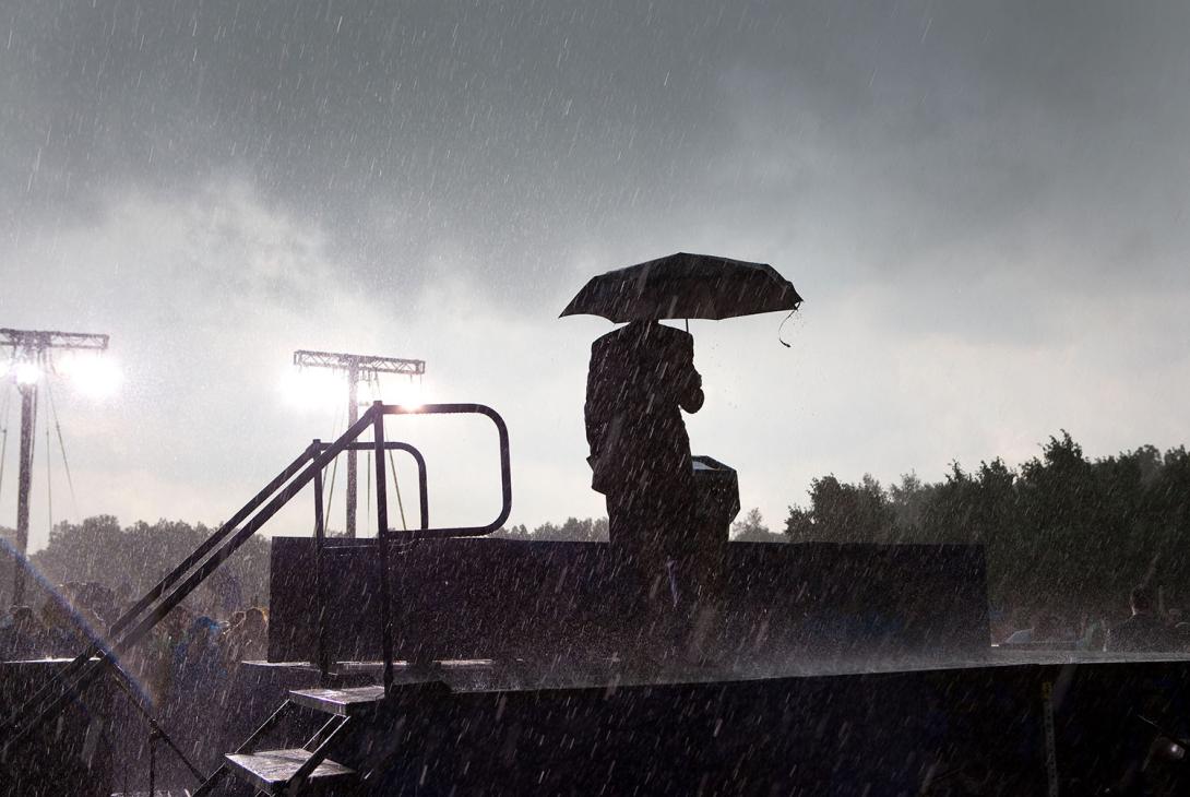 President Barack Obama takes the stage carrying an umbrella amidst a downpour at Abraham Lincoln National Cemetery in Elwood, Illinois, on Memorial Day. He announced that the event was being canceled because of the severe weather, May 31, 2010.