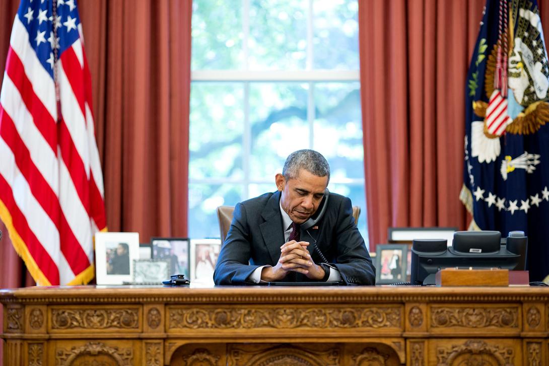 President Barack Obama talks on the phone with pastors who offer a birthday prayer during a call in the Oval Office, August 4, 2015. 