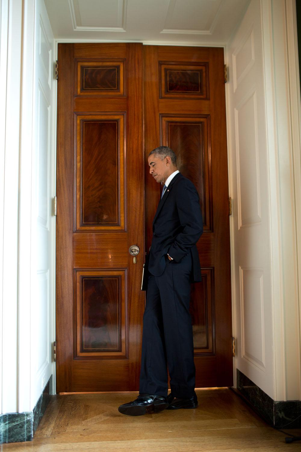 President Barack Obama listens through a door in the Green Room of the White House as Lilly Jay relates her experience as a sexual assault survivor during the launch of the "It's On Us" campaign, a new public awareness and action campaign designed to prev